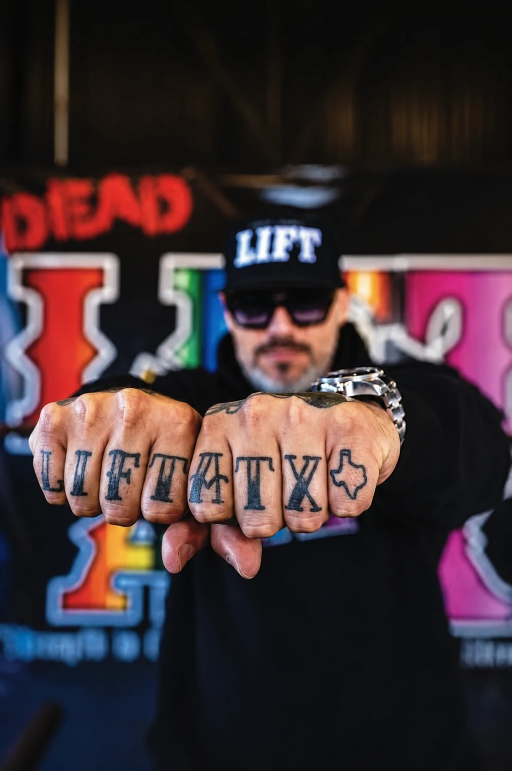 Lift ATX founder Daniel Hinojosa showing his Lift ATX knuckle tattoos